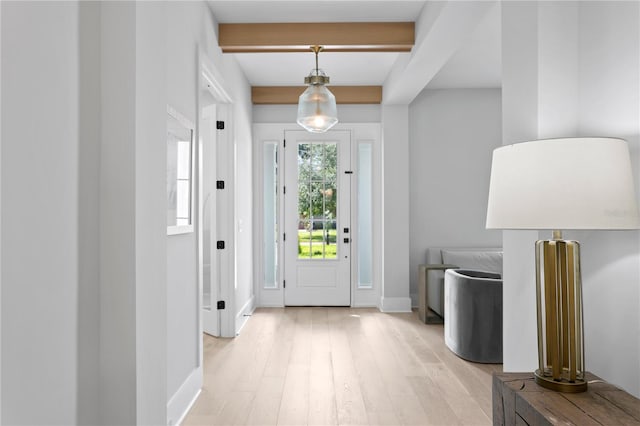 entryway with light hardwood / wood-style flooring and beamed ceiling