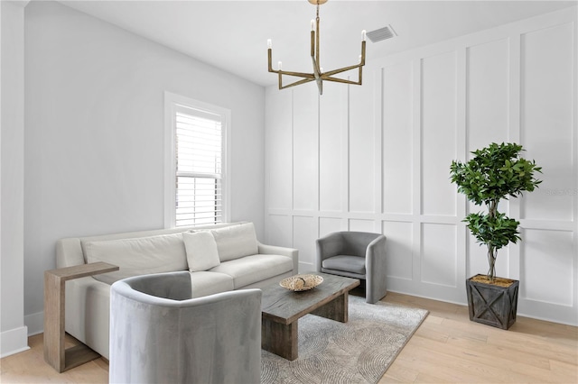 living room with light hardwood / wood-style floors and an inviting chandelier