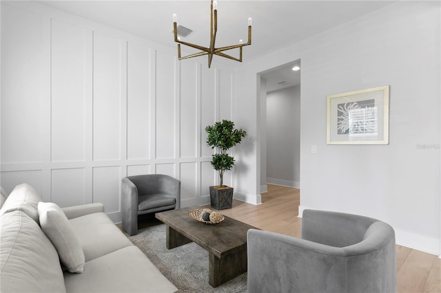 living room with light hardwood / wood-style flooring and an inviting chandelier