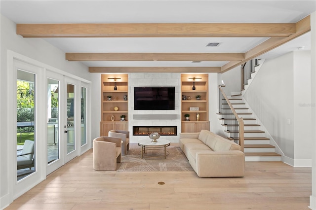 living room with light hardwood / wood-style floors, french doors, and beam ceiling