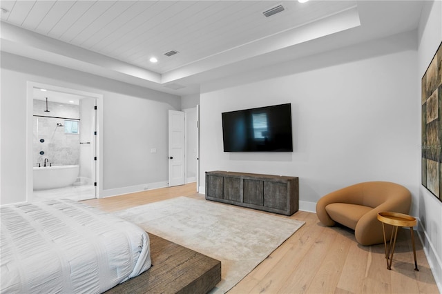 bedroom with ensuite bath and wood-type flooring