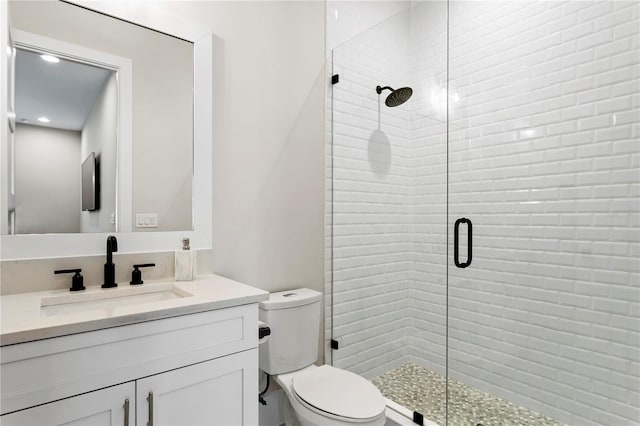 bathroom featuring vanity, toilet, and an enclosed shower