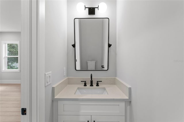 bathroom with vanity, toilet, and wood-type flooring