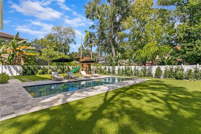 view of swimming pool featuring a patio area, a lawn, and a playground