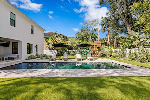 view of pool with a patio, a lawn, and a playground