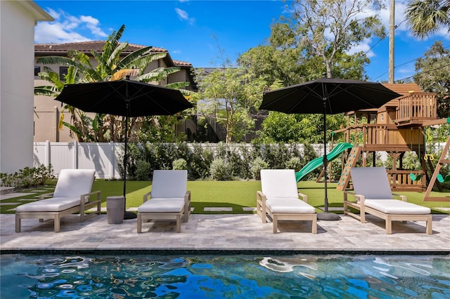 view of swimming pool featuring a patio area and a playground