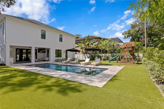 view of swimming pool featuring a patio area, a lawn, and a playground