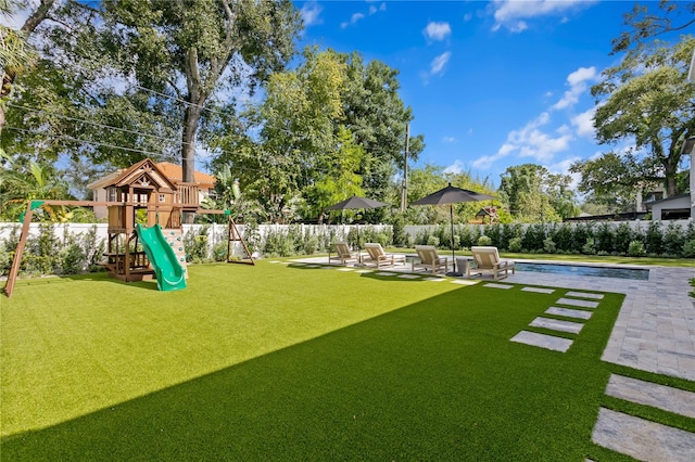 view of yard with a patio area, a fenced in pool, and a playground