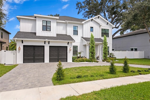 modern farmhouse style home with a front yard and a garage