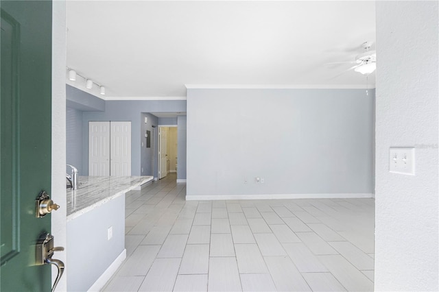 empty room featuring rail lighting, ceiling fan, and ornamental molding