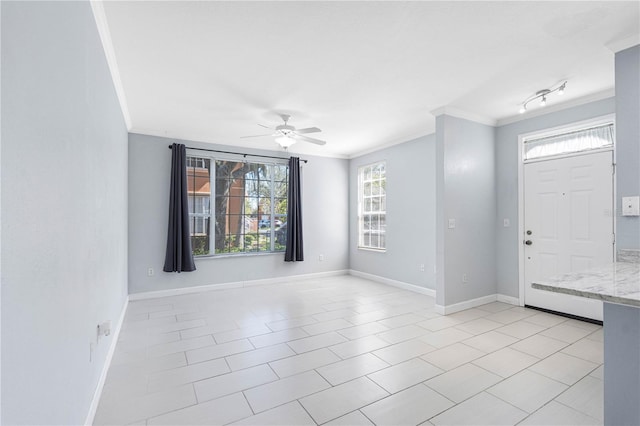 tiled foyer entrance featuring crown molding and ceiling fan