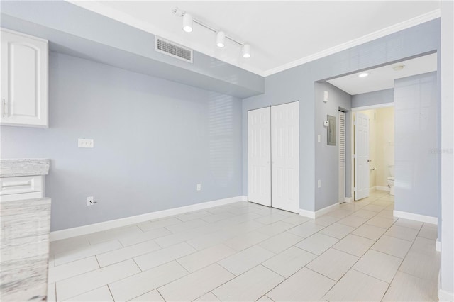 spare room featuring crown molding and light tile patterned flooring