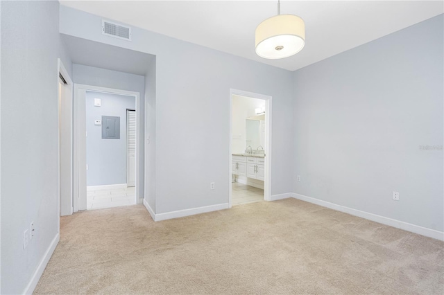 spare room with electric panel and light colored carpet