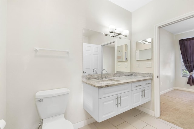 bathroom featuring vanity, toilet, and a chandelier