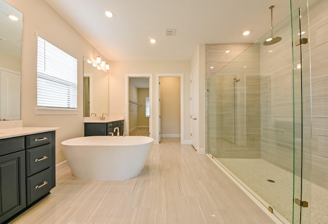 bathroom with vanity, plus walk in shower, and hardwood / wood-style flooring