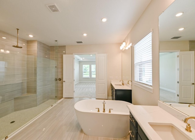 bathroom featuring vanity and independent shower and bath