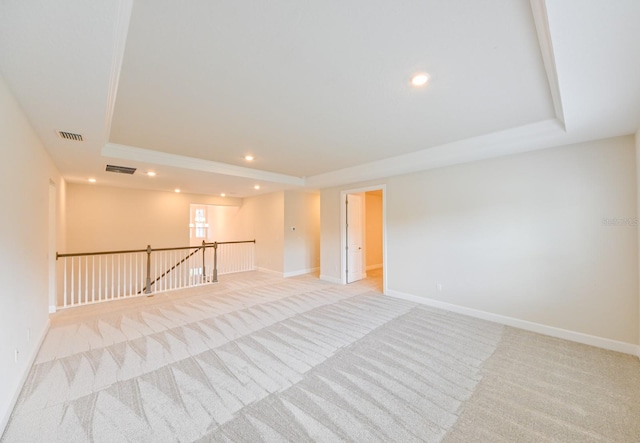 empty room with a tray ceiling and light colored carpet