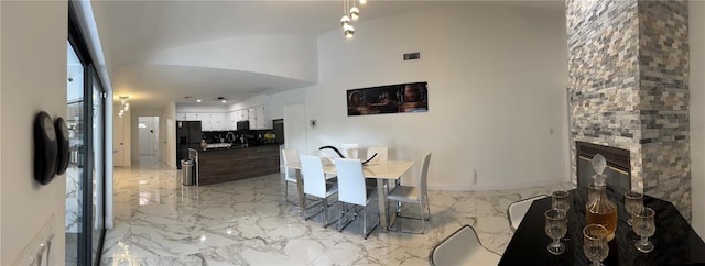 dining area with sink and a stone fireplace