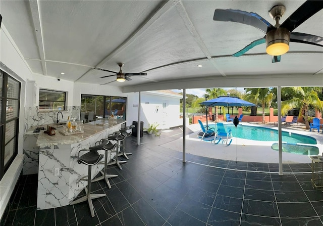 view of pool featuring a bar, a patio area, and ceiling fan