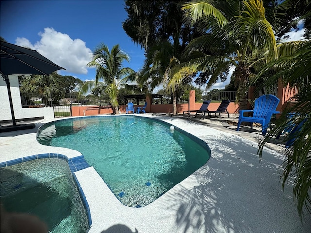 view of swimming pool featuring an in ground hot tub and a patio area