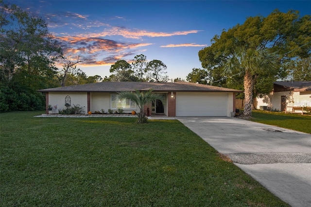 ranch-style house with a garage and a lawn