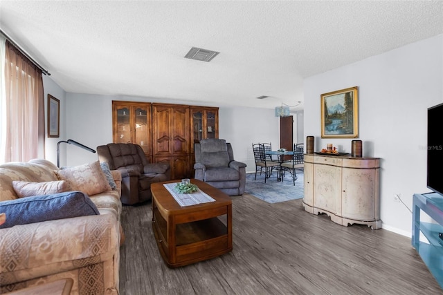 living room featuring dark wood-type flooring and a textured ceiling