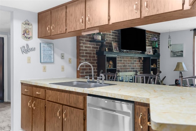 kitchen featuring dishwasher, sink, a fireplace, and kitchen peninsula