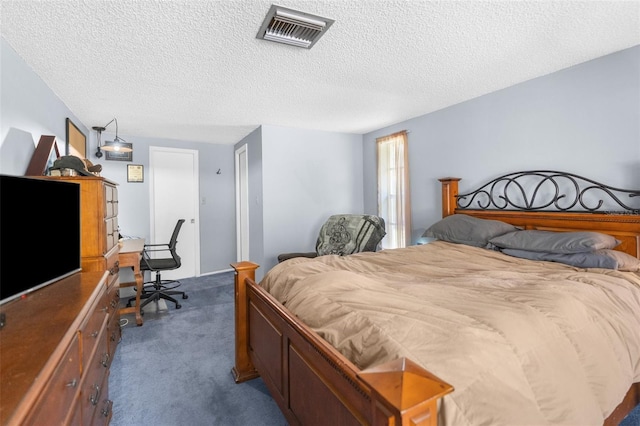 bedroom with a textured ceiling and dark carpet