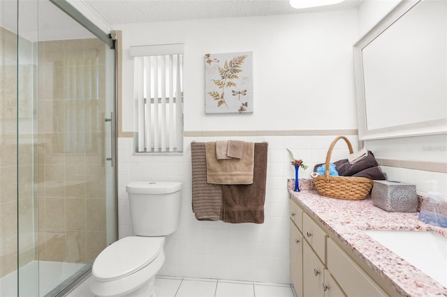 bathroom featuring toilet, tile walls, and a textured ceiling