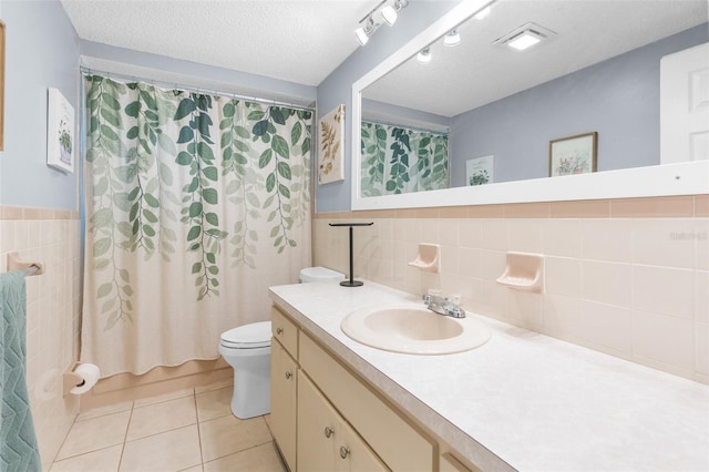 full bathroom with toilet, a textured ceiling, tile walls, vanity, and tile patterned flooring