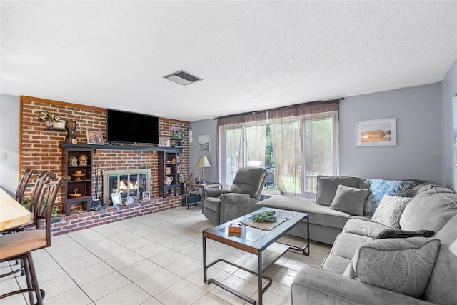 tiled living room featuring a brick fireplace and a textured ceiling