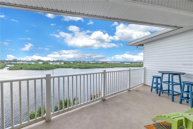 view of patio / terrace with a balcony and a water view