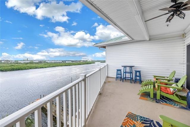 balcony featuring a water view and ceiling fan