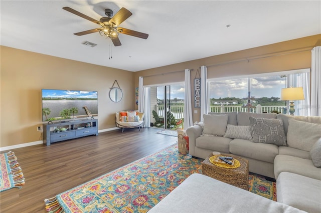 living room featuring ceiling fan and dark hardwood / wood-style flooring