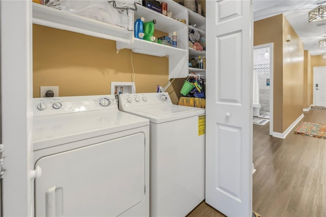 laundry area with washer and clothes dryer and light wood-type flooring