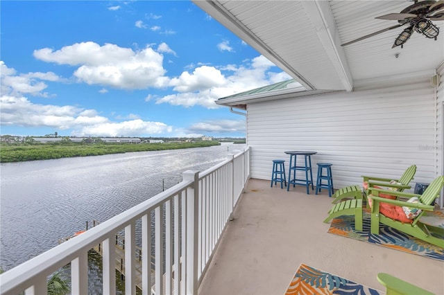 balcony with a water view and ceiling fan