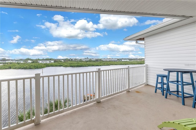 view of patio / terrace with a balcony and a water view