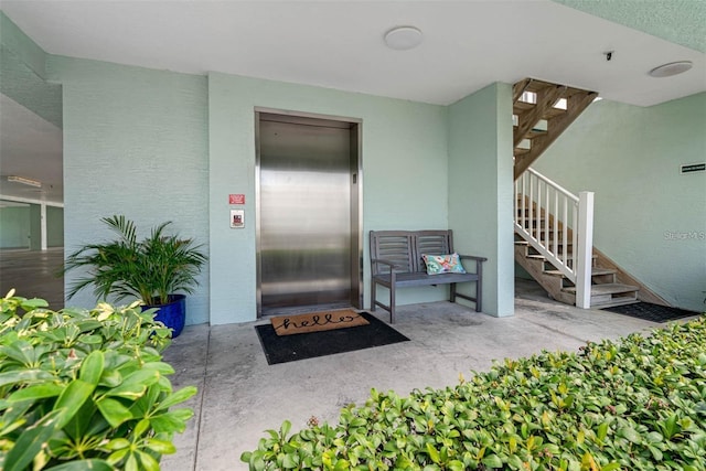 entrance to property featuring a patio area and elevator