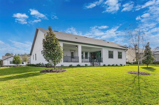 back of house with a lawn and ceiling fan