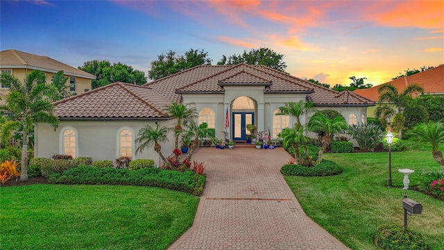 mediterranean / spanish-style house with a lawn