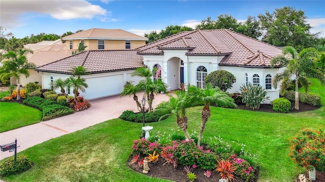 mediterranean / spanish-style home featuring a front lawn and a garage