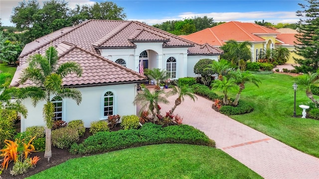 mediterranean / spanish home with a front yard