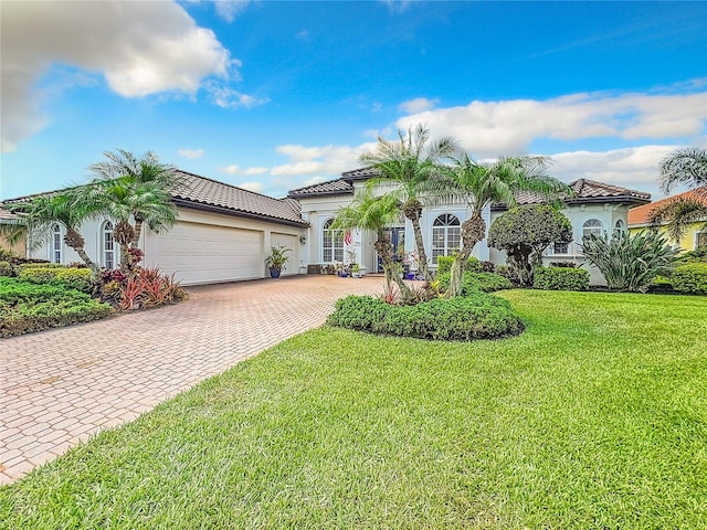 mediterranean / spanish-style house featuring a front lawn and a garage