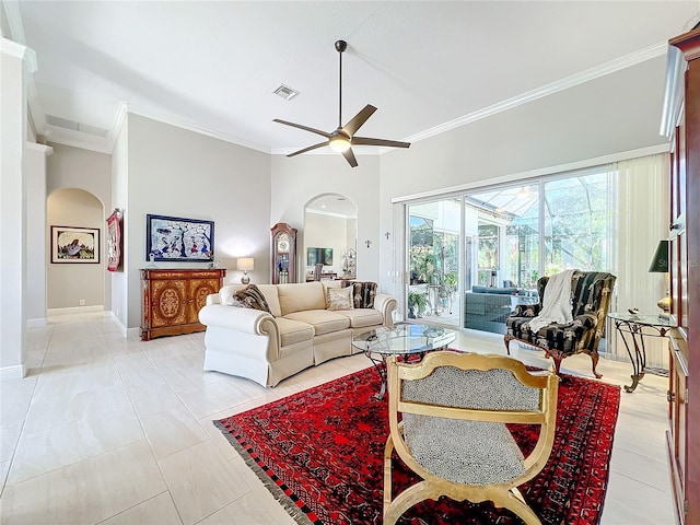 tiled living room featuring ceiling fan, ornamental molding, and a high ceiling