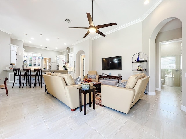 tiled living room featuring ornamental molding and ceiling fan