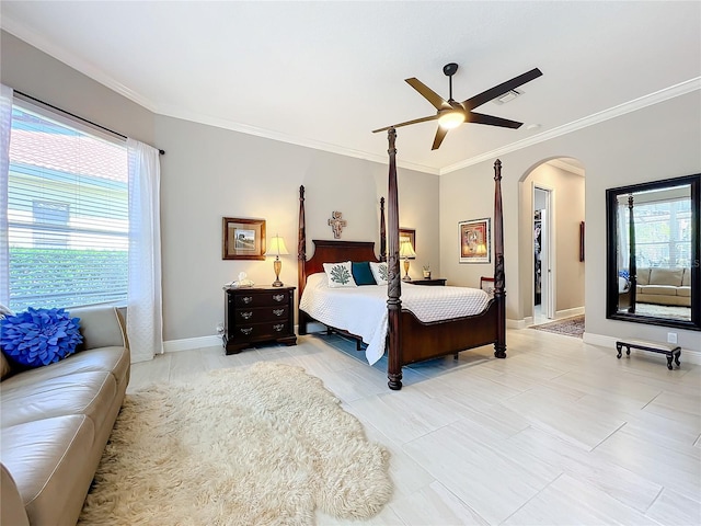 bedroom featuring a spacious closet, ornamental molding, and ceiling fan