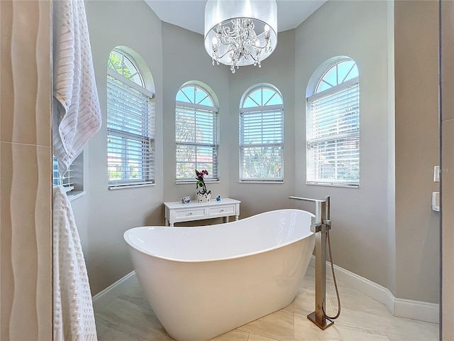 bathroom featuring a bathing tub, vanity, tile patterned floors, and plenty of natural light