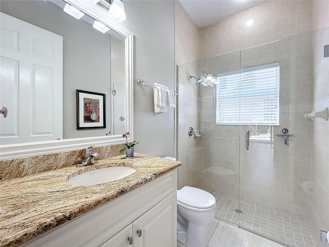 bathroom featuring vanity, tile patterned flooring, toilet, and an enclosed shower