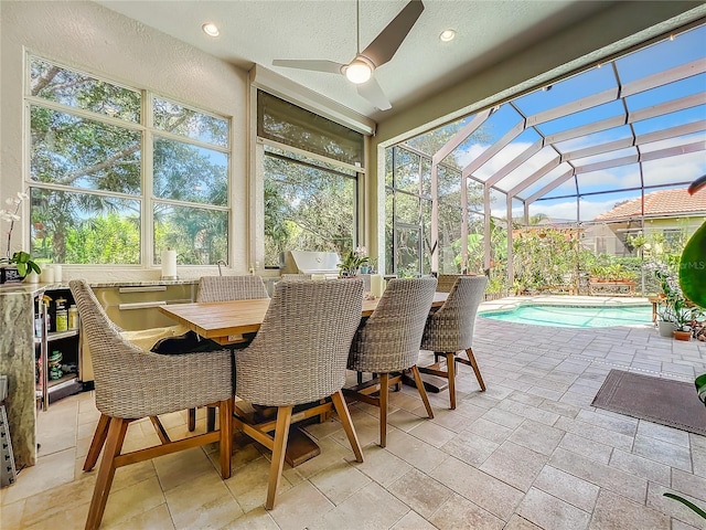 sunroom with lofted ceiling, a pool, and ceiling fan