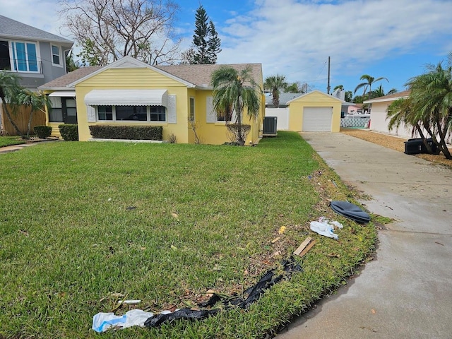 view of front of house featuring cooling unit, a front lawn, an outbuilding, and driveway